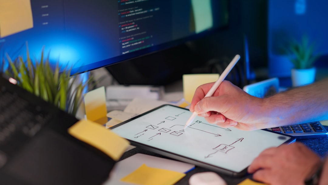 Developer Drawing Project Diagram Digital Tablet home studio equipment modern tech workspace with multiple screens and programming code. Concept of software planning, UX flowchart, system architecture and agile design process